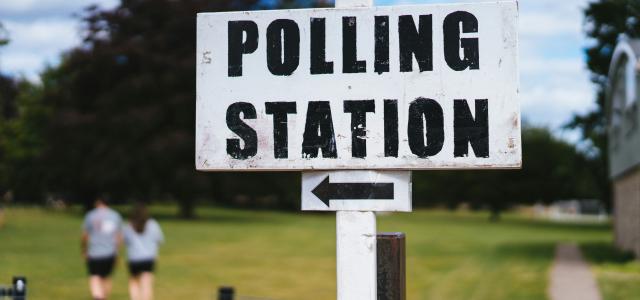 A pole with a sign that says polling station by Phil Hearing courtesy of Unsplash.